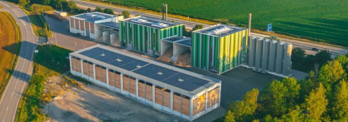 Central de biomasa junto a la planta BMW de Dingolfing con área de acopio de madera y cargadora frontal